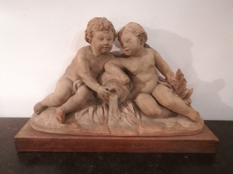 Group of terracotta puttis with amphora and oak base