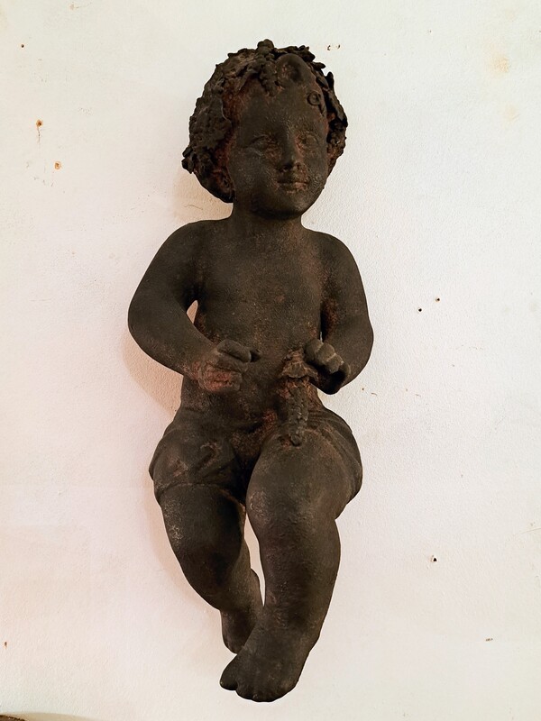 Hanging Bacchus child in terracotta with dark patina